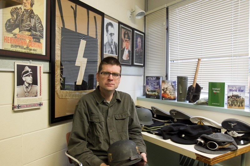 Andrew Kelly shows off some of his Second World War memorabilia including helmets, hats and banners on Oct. 11.