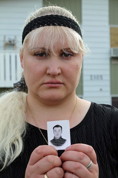 Veronika Kuznetsova holds a picture of her husband Alexander, who died from a heart attack at the age of 37 on Oct. 20. Kuznetsova is now trying to return to Russia to be