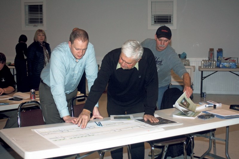 Paul Gustafson, owner of the Olds Shoppers Drug Mart, and Larry Wright, the town&#8217;s strategy and technology officer and former director of operational services, discuss