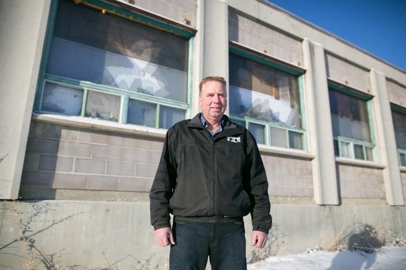 Paul Leussink in front of the abandoned Bowden nurseries building with smashed windows in the background.