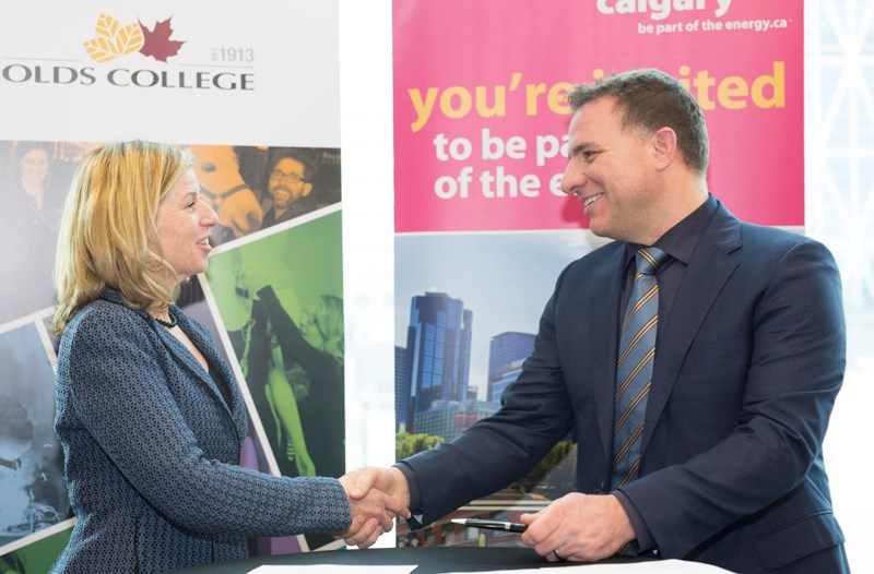 Olds College president Stuart Cullum and Calgary Economic Development president and CEO Mary Moran shake hands after signing a memorandum of understanding creating the