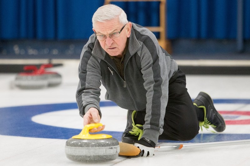 Ron Urbanowski throws a rock during the Olds Farmers and Farmerettes bonspiel at the Olds Curling Club.