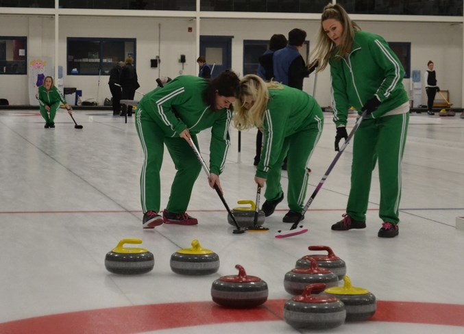 Brandee Lentz, Jodi Carrington and Claire Rosehill combine to sweep a rock to the house during the Ladies&#8217; Open Bonspiel, held March 2-4 at the Olds Curling Club.