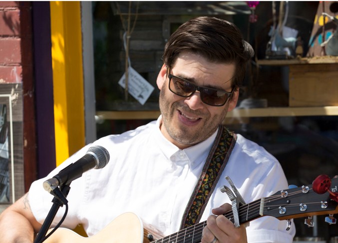  Michael Brown performs on the sidewalk along 50th Avenue.