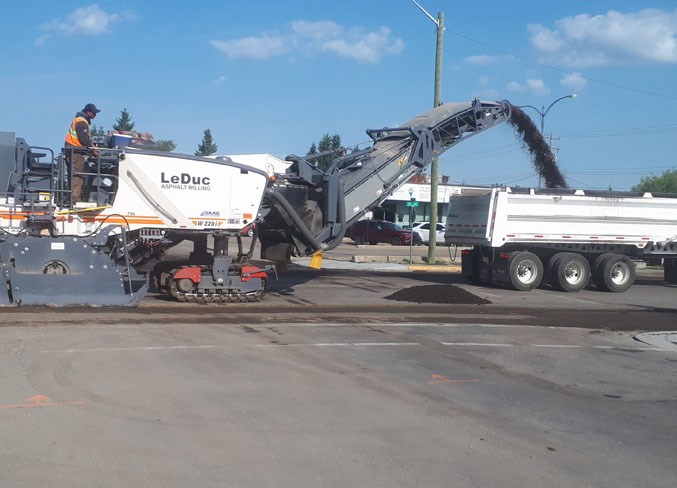 Workers strip asphalt off 52nd Avenue in preparation for paving.