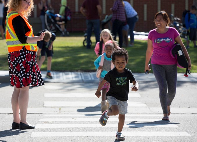 Students cross the street in front of Olds Elementary School on September 3.