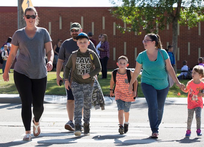 Students cross the street in front of Olds Elementary School on September 3.