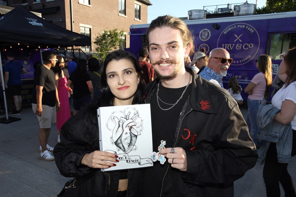 Anastacia Pecherskaya and Carson Madill love their Victoria Gale drawing at last night's Night Market, hosted by the Newmarket Group of Artists and Town of Newmarket. 