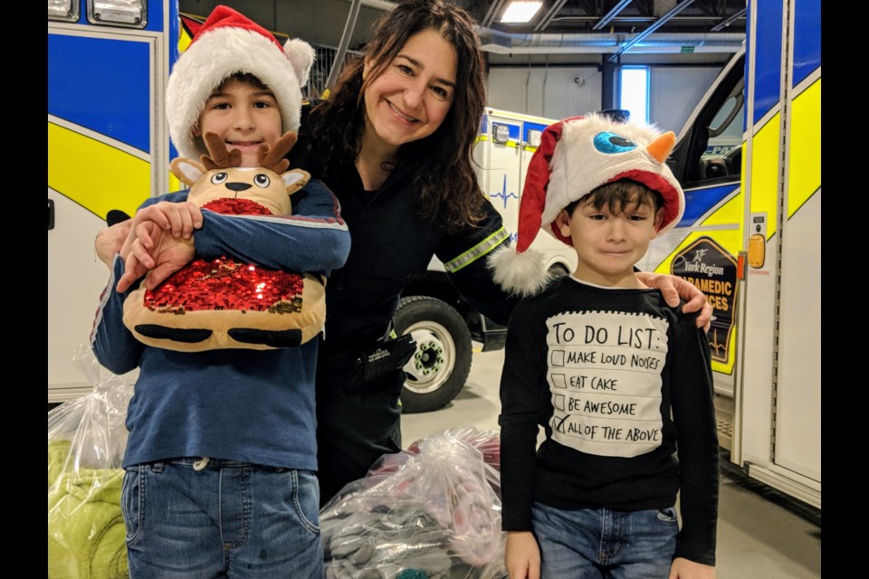 York Region Paramedic Services field teaching officer, Helen Galanis, has been organizing the Christmas Eve delivery of toys and blankets for 11 years. She's shown here with her two sons, Cole and Brady MacArthur. Kim Champion/NewmarketToday