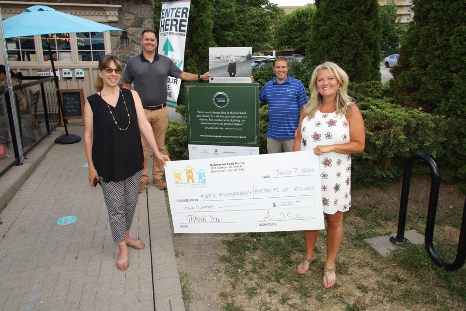 Karen Merk of Portraits of Giving, Adrian Bain and Kirk Bowden of the Newmarket Food Pantry, and Juliane Goyette celebrate a $200 donation to the food bank.  Greg King for NewmarketToday