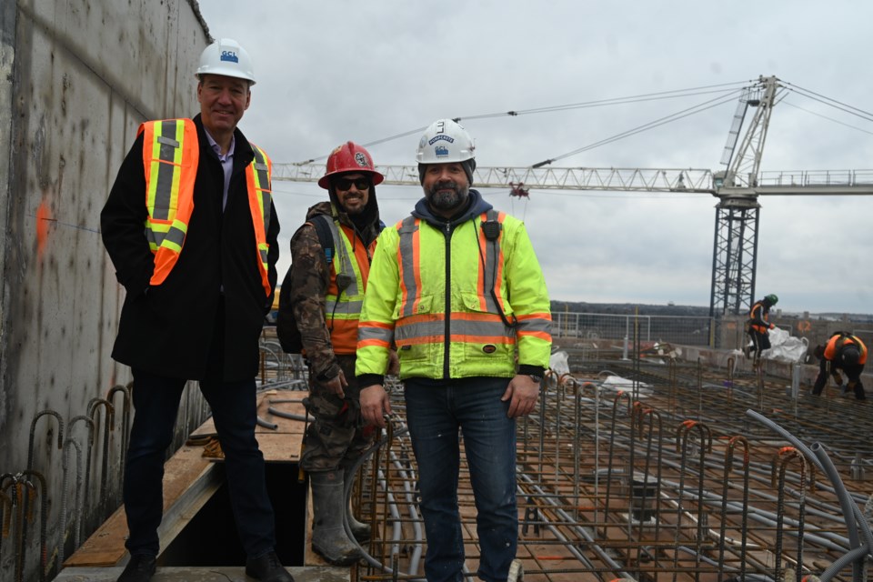 Newmarket Mayor John Taylor, worker Thiago Santos and construction supervisor Modrek Farhat stand on the roof of the Kingsley Square condos first tower Dec. 17. 