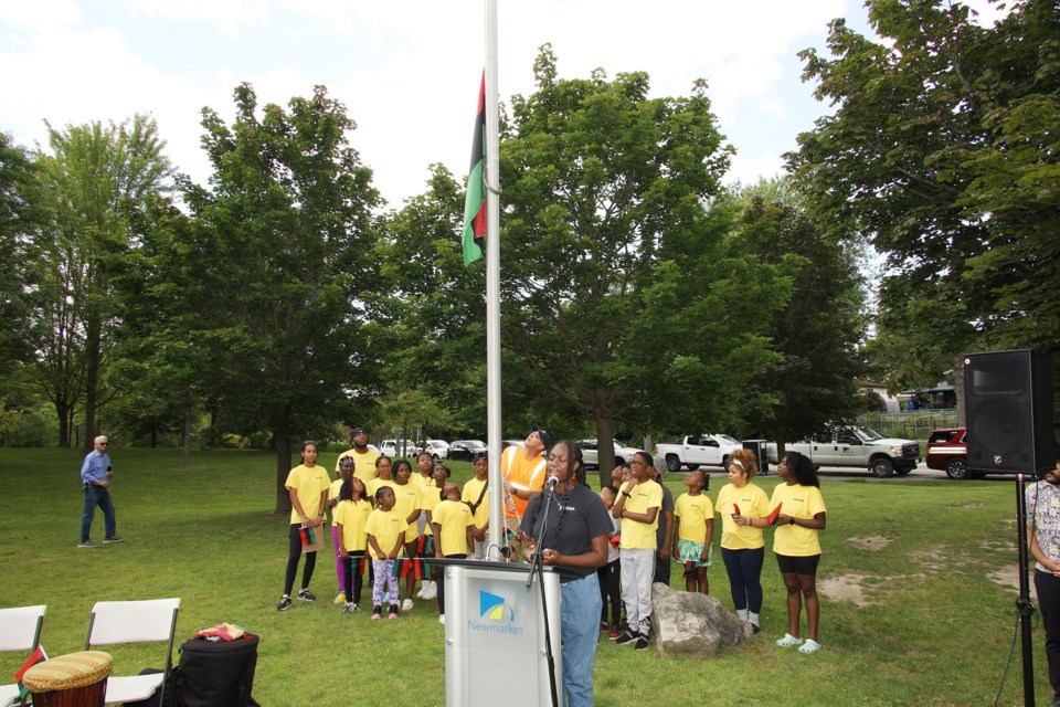 The Pan African flag is raised at Newmarket's Peace Park on Emancipation Day today, as Laylah Hall sings the Black national anthem at the ceremony hosted by the  Newmarket African Caribbean Canadian Association.  Greg King for NewmarketToday