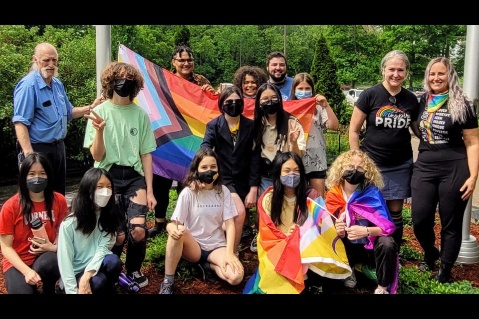 Natalie Zuchlinski (right), and Bonnie Skinner along with students from Cornell Village P.S. pose with the Pride flag before it is raised. 