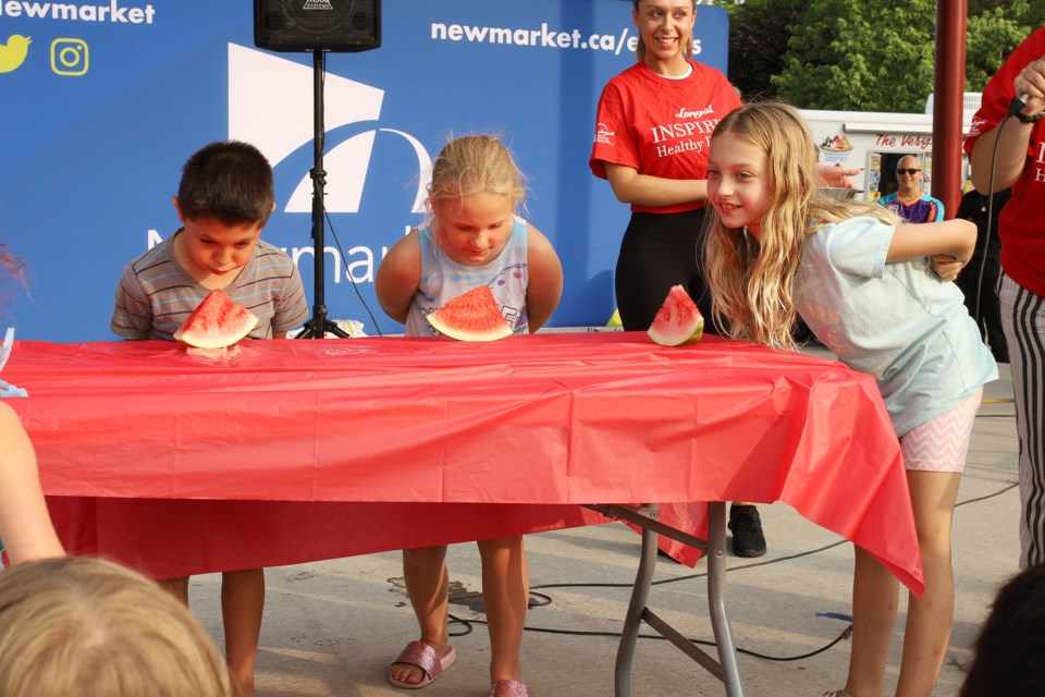 Mark, Summer and Stephanie get ready to dig in at the watermelon-eating contest sponsored by Longos  at Kids Downtown last night.  Greg King for NewmarketToday