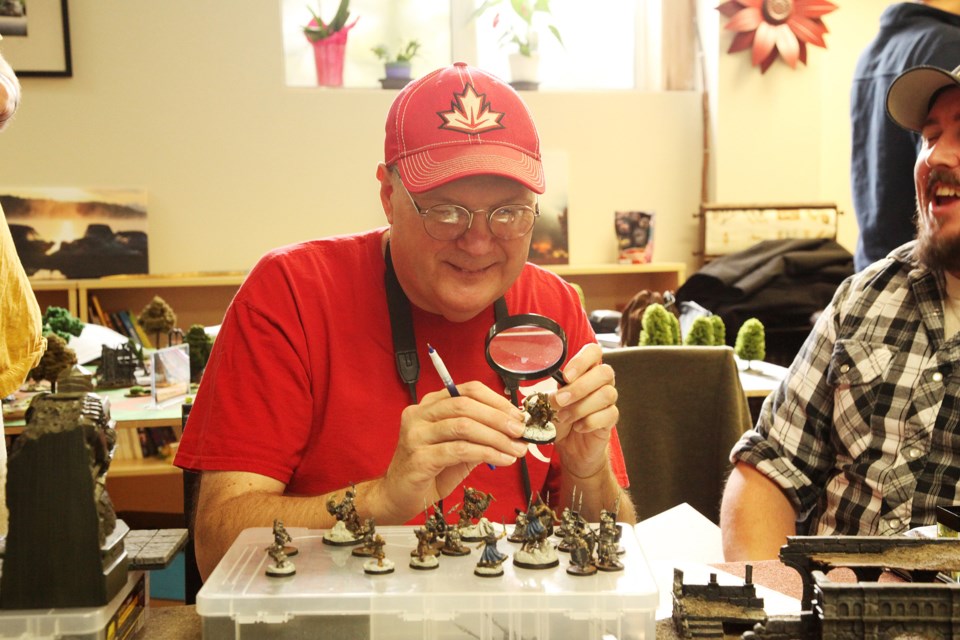 Ontario Strategy Battle Game League (OSBGL) organizer Don Barnett examines the painted detail on a miniature.  Greg King for NewmarketToday