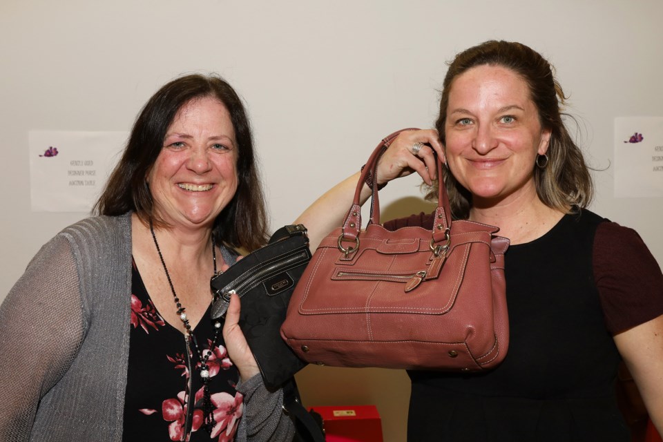 Eileen Galloway and Tanya Brethour have their bids in on these purses at Bereaved Families York Region's annual Purse Party and Auction April 17 at Newmarket Community Centre. Greg King for NewmarketToday