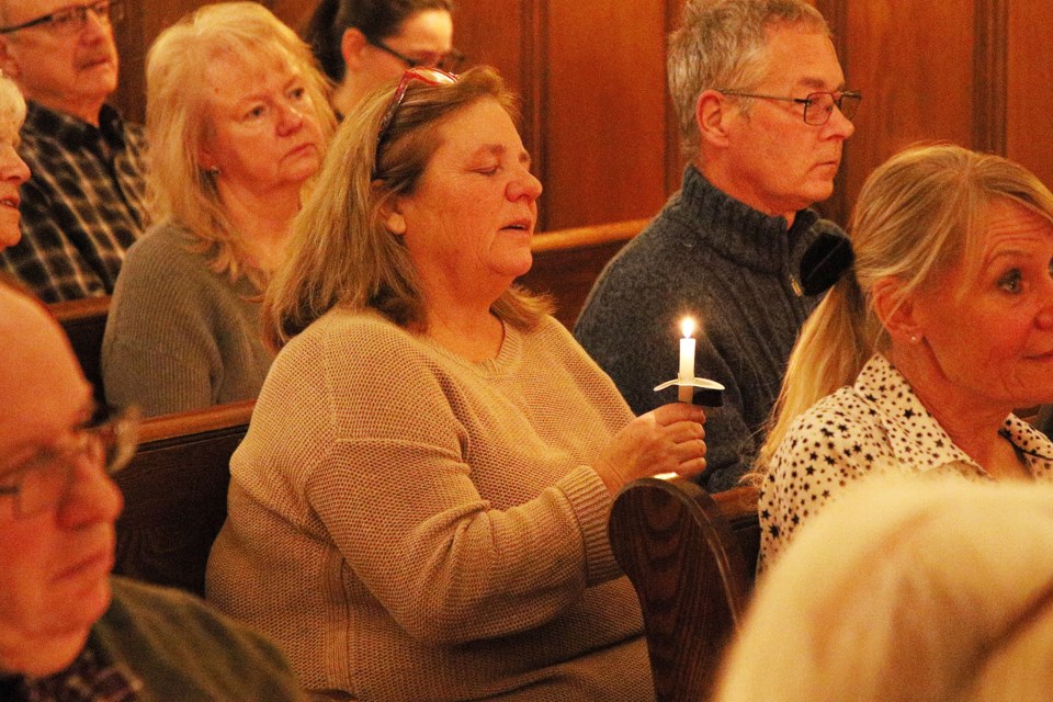 Shelley Dutton holds a candle during the Holiday Community Candlelight Vigil hosted by Genesis Bereavement Resource Centre and Roadhouse & Rose Funeral Home Sunday, Dec. 8 .  Greg King for NewmarketToday