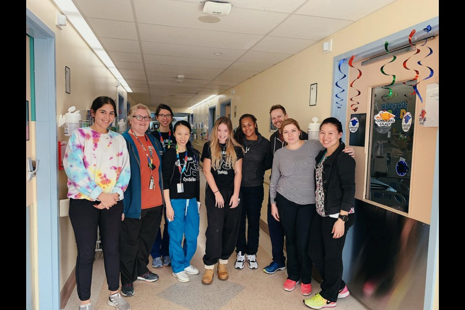 Madi Vanstone (center) gathers with some of the clients and staff members at the Hospital for Sick Children.