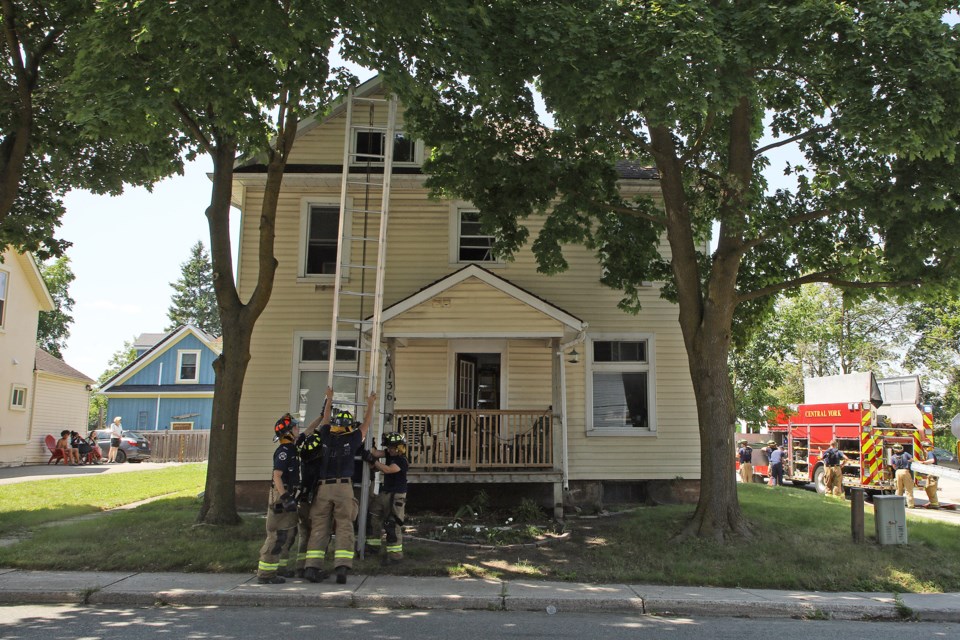 Firefighters put away one of the ladders they used to get at the upper floor.  Nobody was home upstairs.