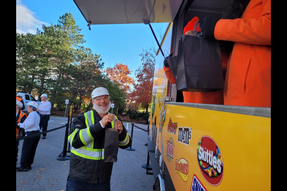 A plant worker smiles as he receives a bag full of candy from the Mars truck.