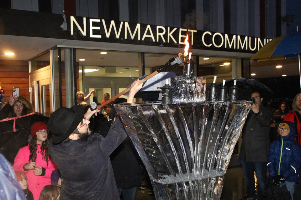 Rabbi Grossbaum lights an ice menorah for the Newmarket Chanukah Festival at the Riverwalk Commons Dec. 29. 