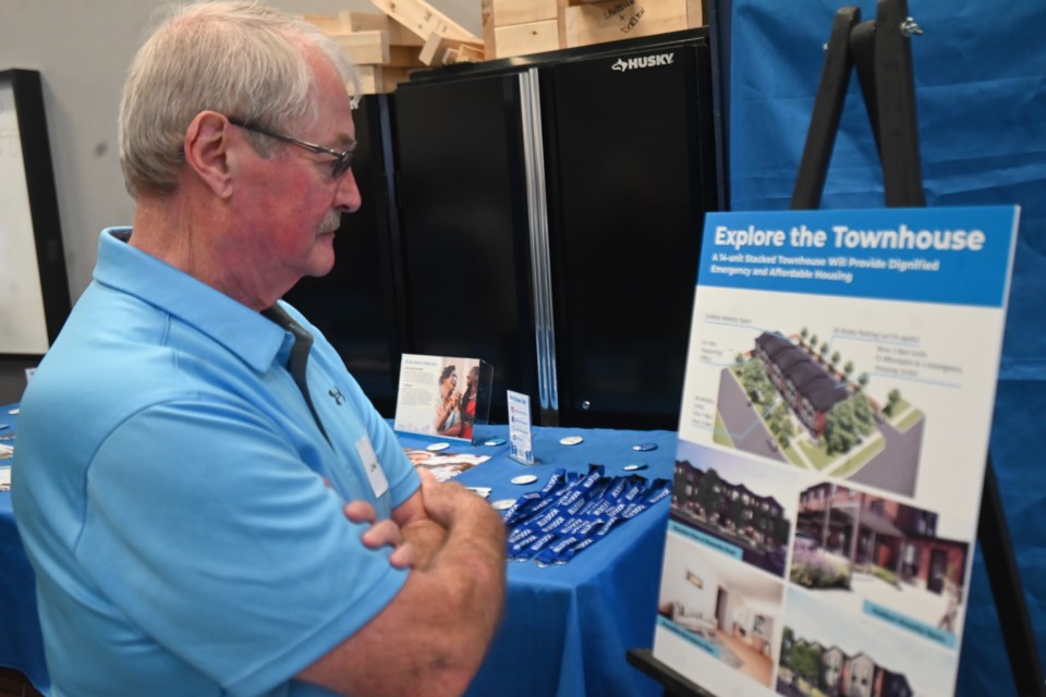 Newmarket resident Joe Heally looks at one of the posters at an information event about the new Blue Door housing project on Gorham Street.