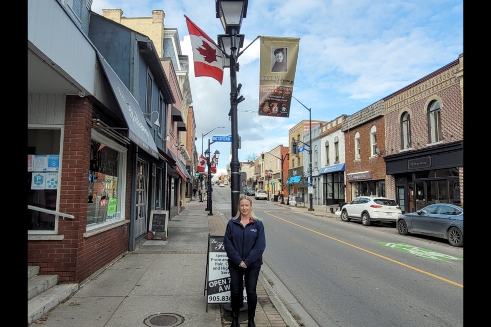 Crystal Cook stands in front of the banner for her grandfather, George Stephens, who served in the Seond World War. 