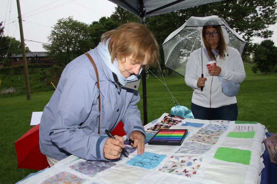 Grief Healing Support Centre (Bereaved Families of Ontario - York Region) held a Community Gathering for Hope and Healing at Fleury Park in Aurora May 25. Maria Scanga leaves a message on the community quilt.