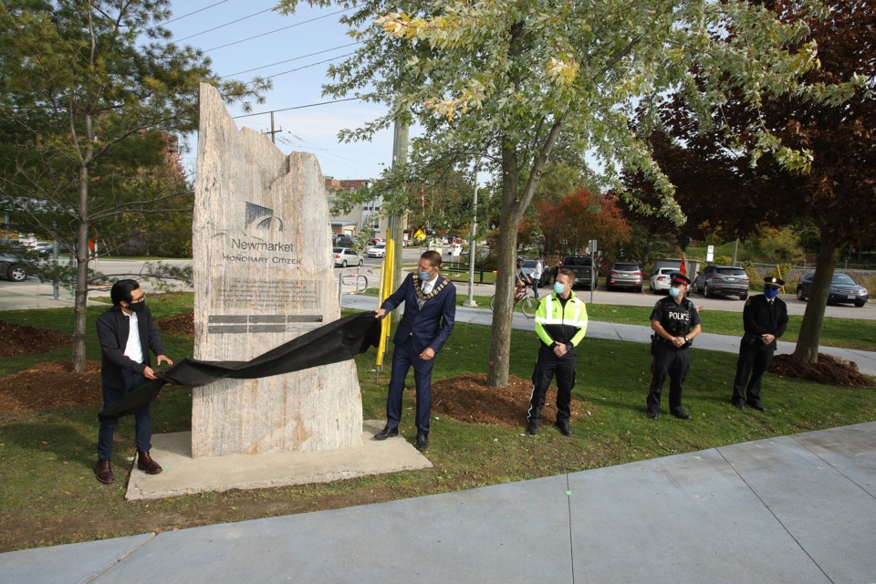 Alfonso Sarmiento and Mayor Taylor unveil the new plaque on the monument.  Greg King for NewmarketToday