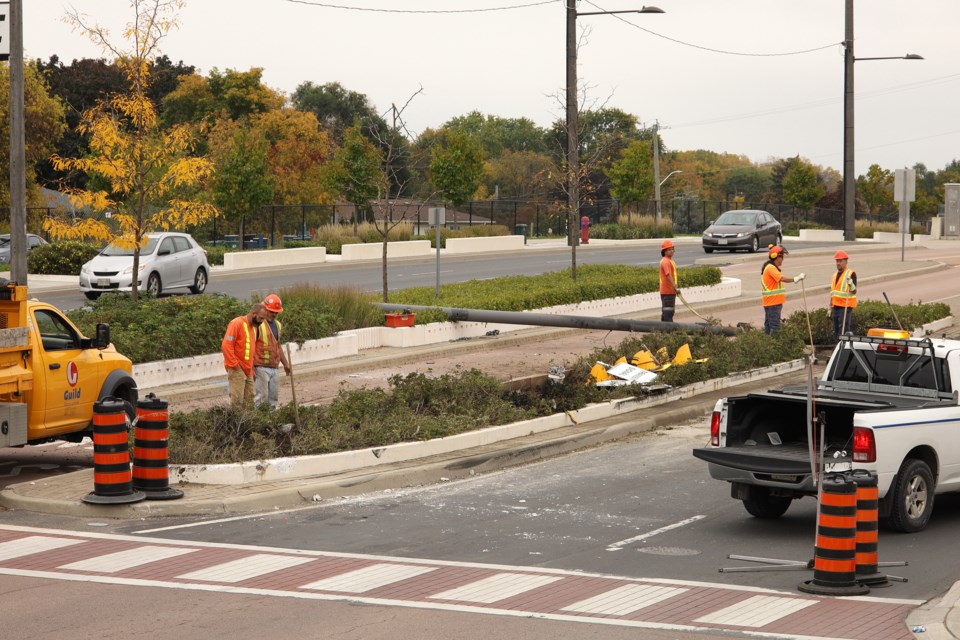 Repair crew looks at the hole where the traffic light pole used to be on Davis Drive after it was struck by a gravel truck Oct. 7.  Greg King for NewmarketToday