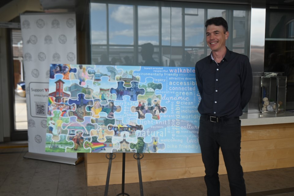 Artist Jeff Nye stands next to his piece depicting a future vision for Newmarket. 