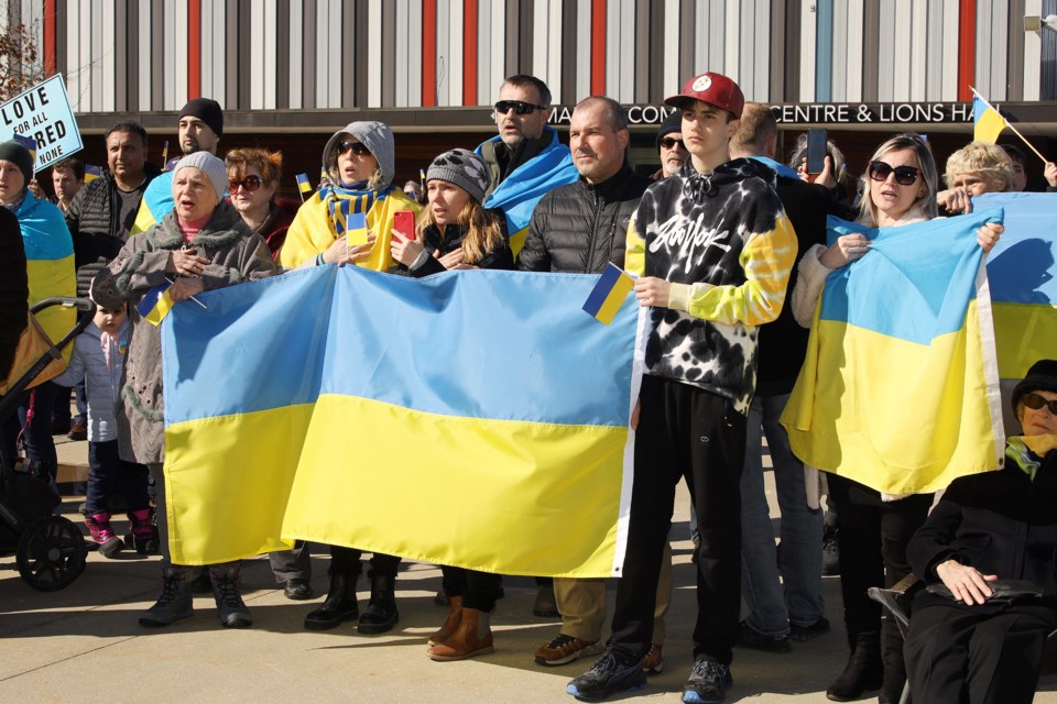 Olga Grbyuk, Adriana Khonyn, Valentina Burbelo, Louis Encimas, David Burbelo, and Oksana Kobzer singing the Ukrainian national anthem at the vigil Sunday afternoon at Riverwalk Commons.  Greg King for NewmarketToday