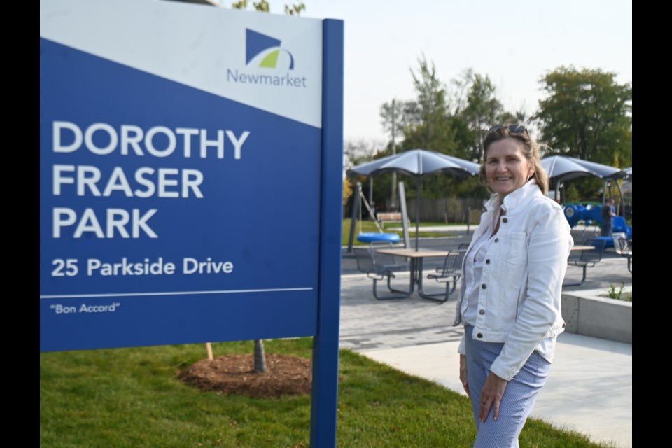 Fiona Fraser stands next to the sign for a new park, dedicated to her late mother. 