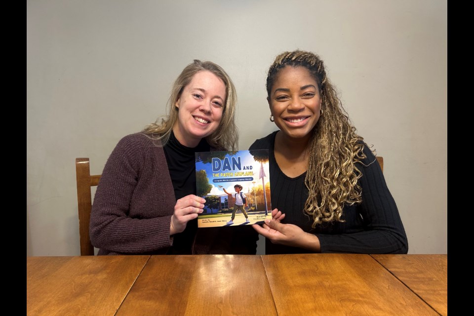 Jinean Cheng (left) and Camesha Russell display Dan & The Paper Airplane: Living Life With Developmental Language Disorder, the first children's book in their upcoming book series.