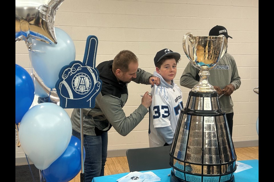 Toronto Argonauts kicker 
Lirim Hajrullahu signs the jersey of York Region Lions player Evan Neuendorf at a visit in Newmarket last night at the community centre.
