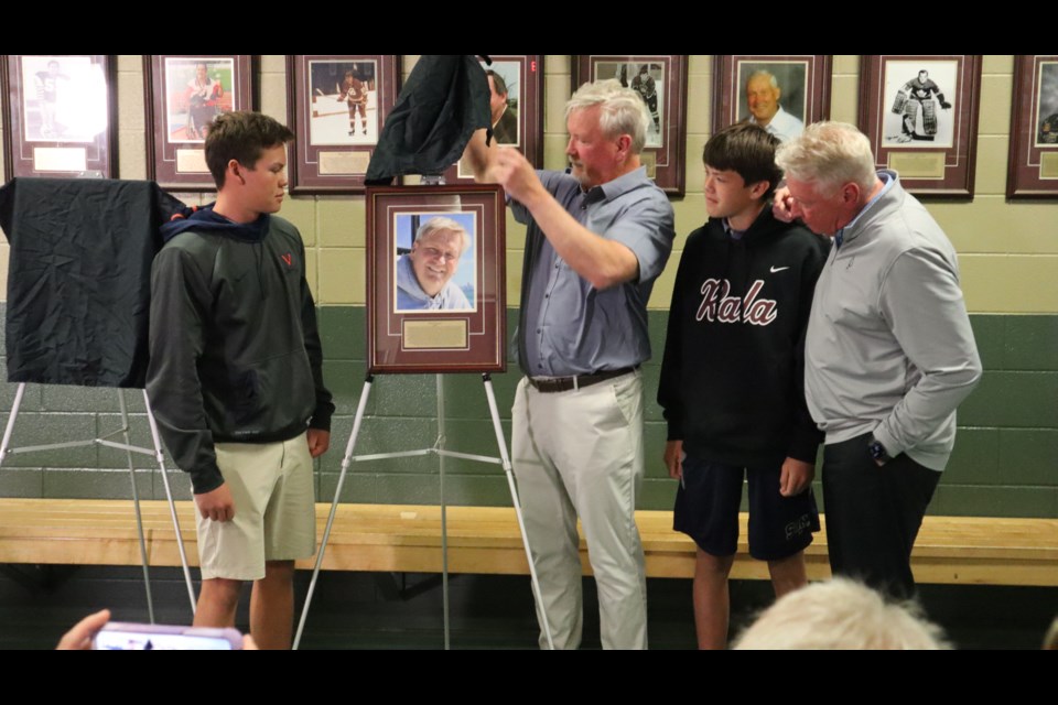 With the help of his two sons Colin (18, left) and Zach (15, right) and his brother Mike, Paul French unveils his Wall of Fame plaque