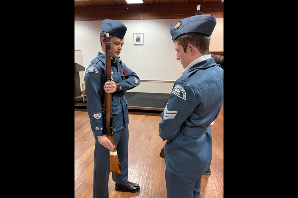  Warrant Officer Second Class Deane inspects a cadets hold during rifle drill.