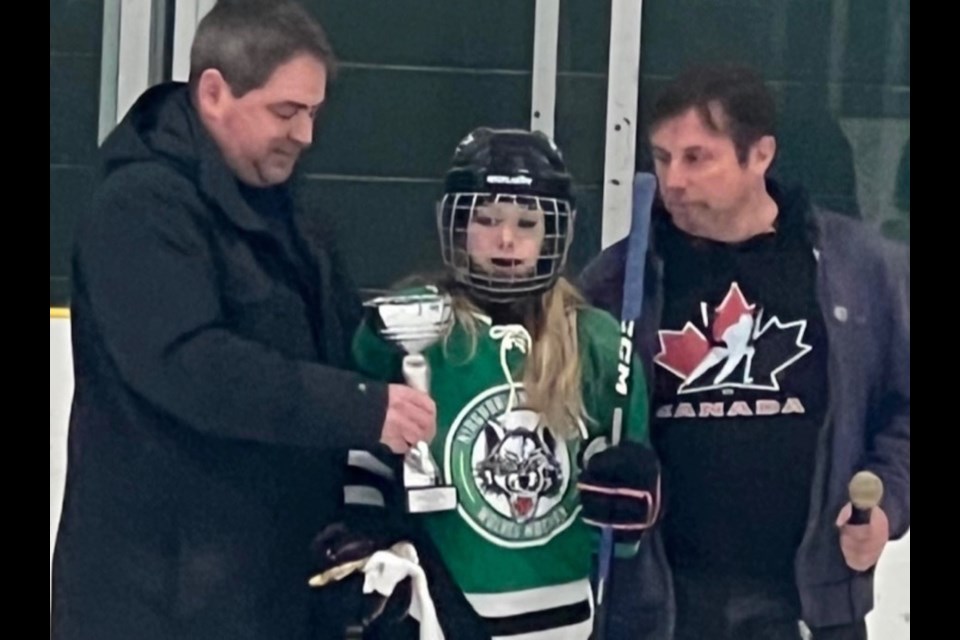 Ariel Carr is presented with a trophy by Phil Leboudec and James Cadeau after the U13 Wolves exhibition game last Thursday.