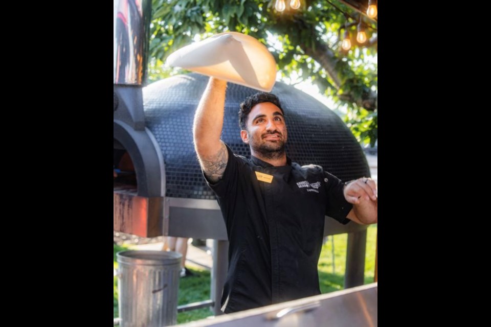 Executive Chef Michael Zappitelli hand tossing pizza dough.
