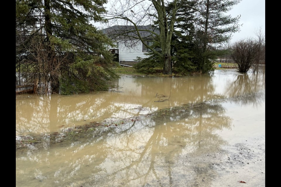 A house at the corner of Concession 7 and Line 8 is surrounded by rain water.