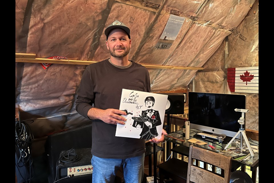 Scott Gossen holds up a vinyl copy of his new album in his loft studio in Virgil. 