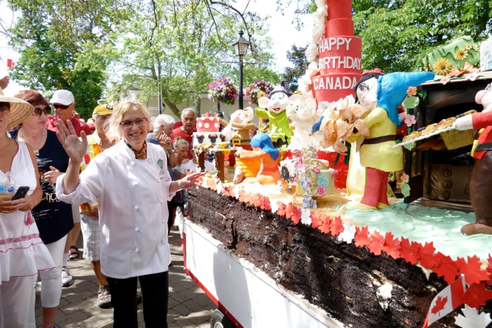 Catherine O'Donnell with one of her Canada Day creations, in the annual cake parade down Queen Street. (File photo)