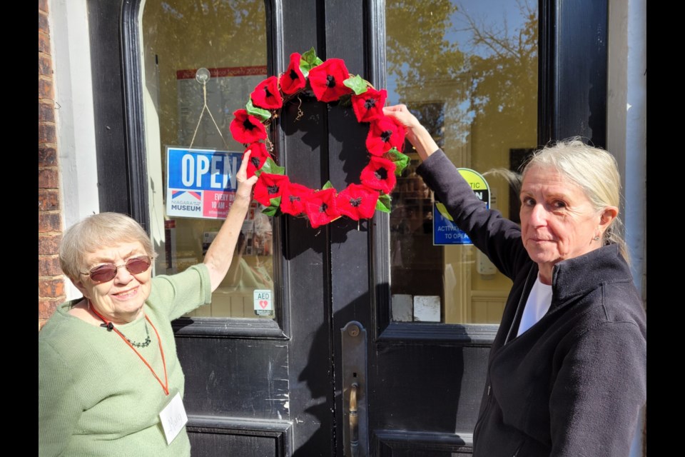 Marg Teare and Peggy Bell show off one of the wreaths made for the museum door and some Queen Street businesses.