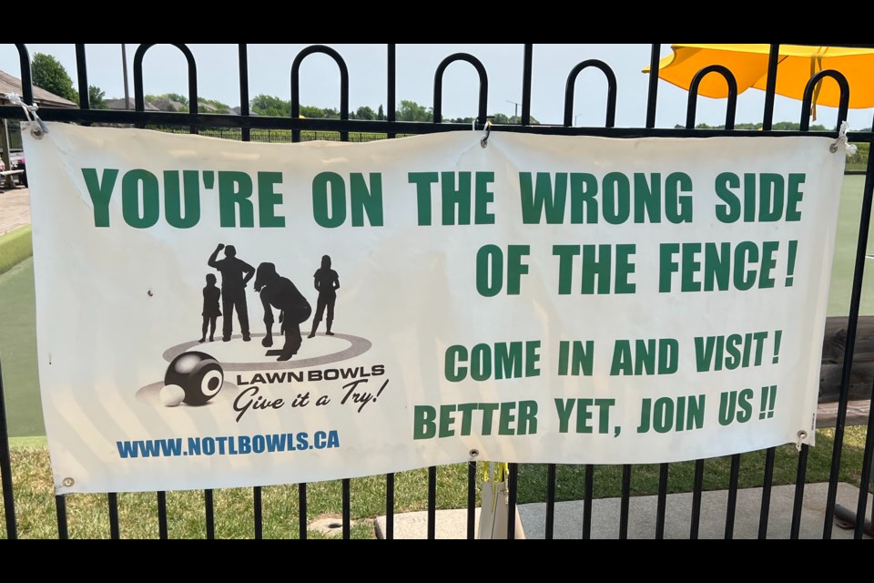 A sign on the lawn bowling fence encourages potential players to visit, and better yet join. 