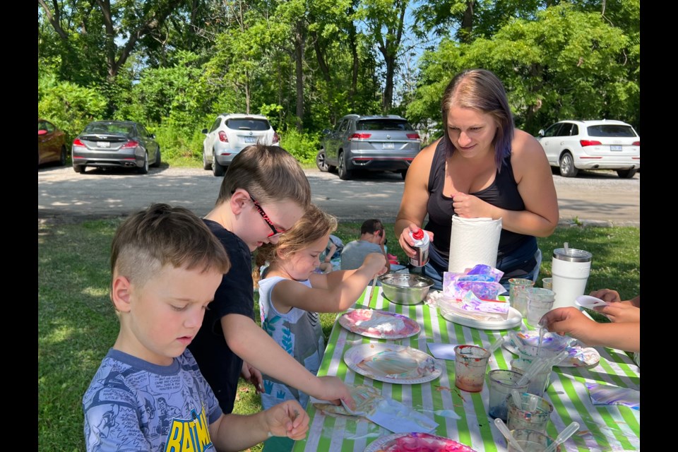 Liam, Callum and Fiona with Kasia Dupuis, a library services associate, at a summer library pop-up session.