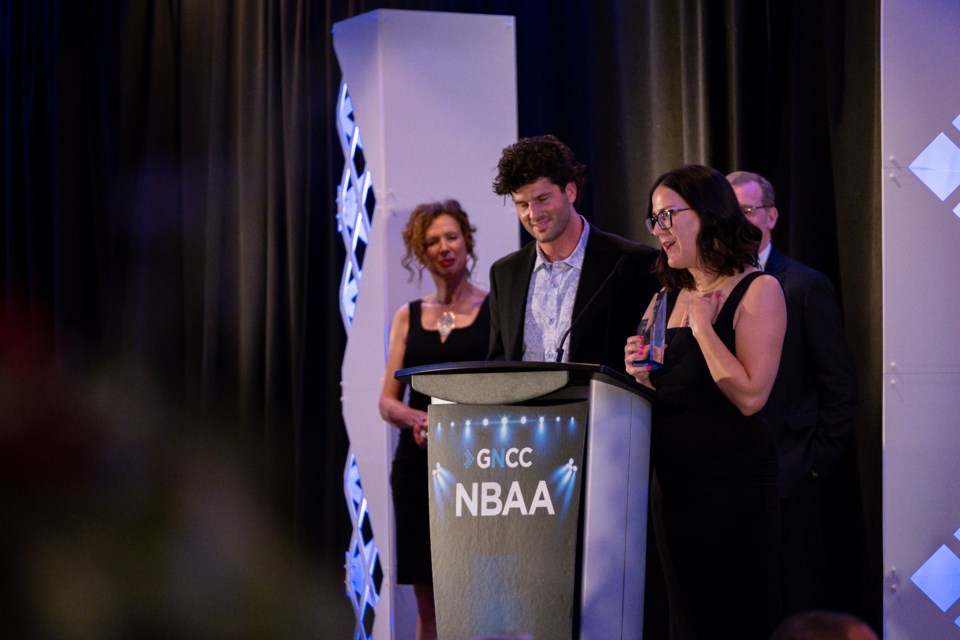 Josh Graham and Erin VanBussel of Silversmith Brewing at the podium to accept the brewery's Business of the Year award. 