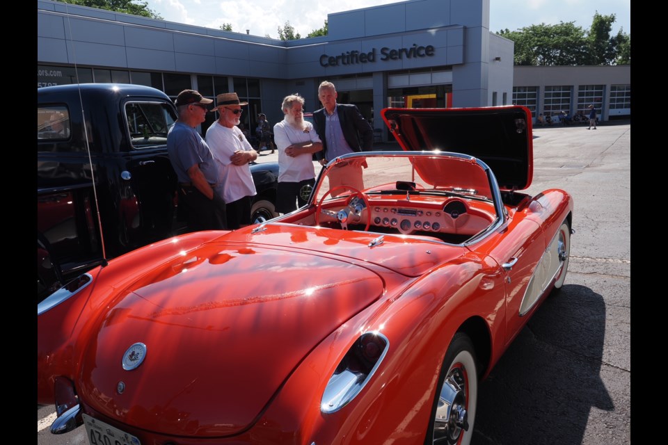 Dave Dick with car owners admiring a classic corvette at the third annual Niagara Motors car show.