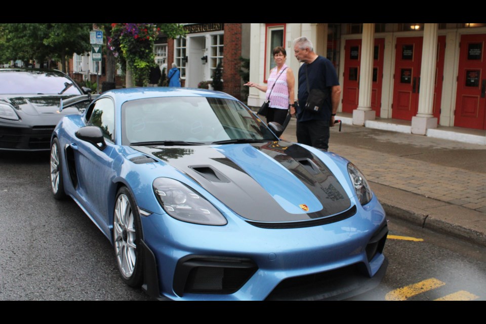 Carole Gorman and Rob Rebmann took advantage of a break in the rain Friday morning to check out a Porsche Cayman GT4 RS. The vehicle was one of many exotics on display on Queen Street at the A & R Solutions Niagara 5000 on Friday.