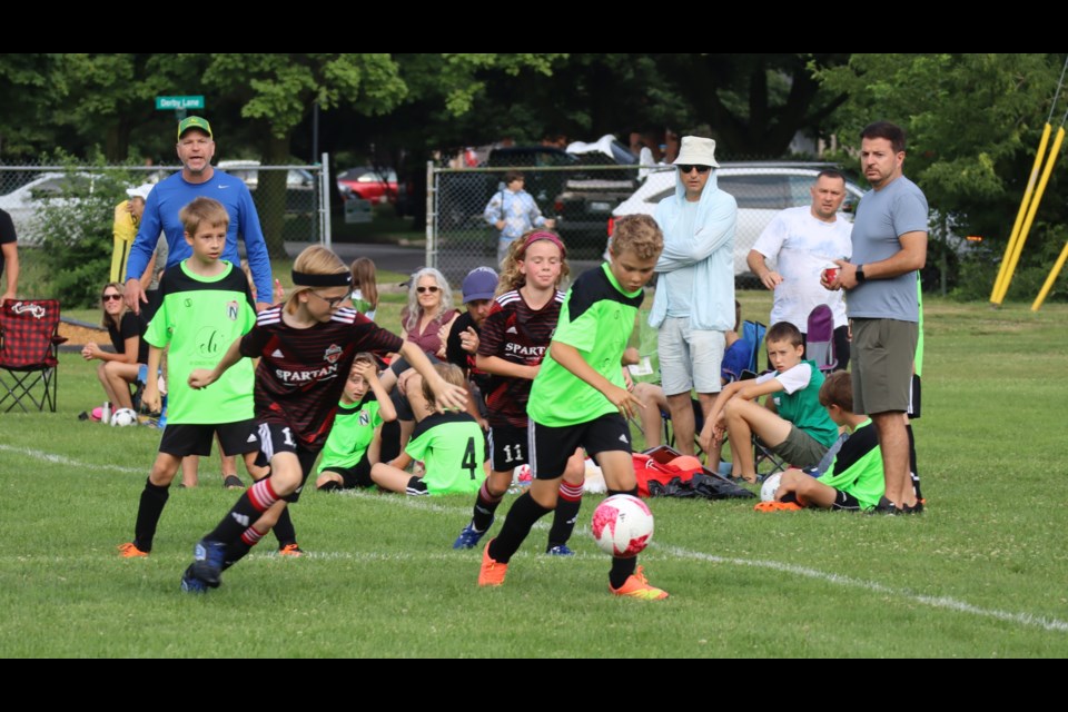 Wyatt Neufeld fights for the ball against a Paris defender while Edwin Shepard provides support