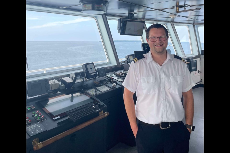 Second office Lawrence Hartwick stands next to radar equipment on the MS Chi-Cheemaun. 